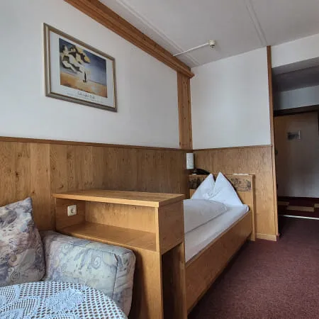 Innenansicht eines Hotelzimmers mit Holzwänden und einem Bett