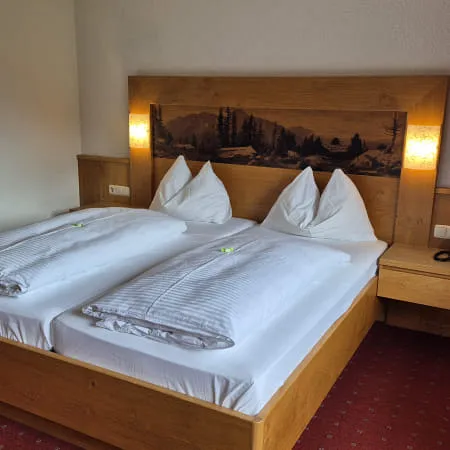 Hotelzimmer mit einem Doppelbett und dekorativer Wandkunst
