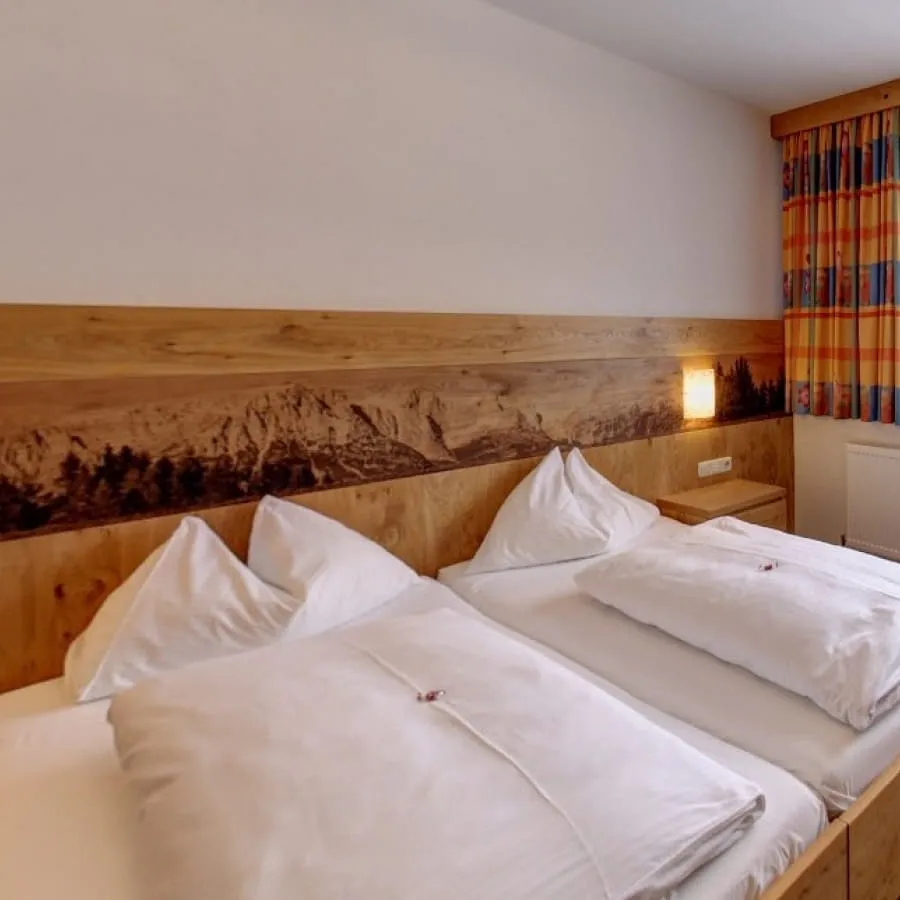 Modernes Schlafzimmer mit Holzdetails und zwei Betten.
