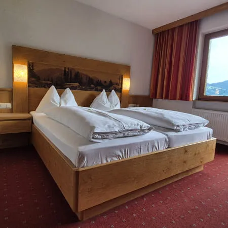 Zimmer mit Doppelbett, Fenster und schöner Aussicht