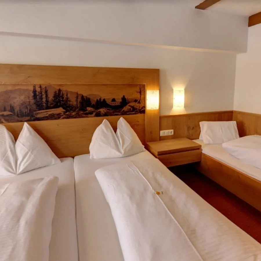 Dreibettzimmer mit Holzdekor und zwei Einzelbetten