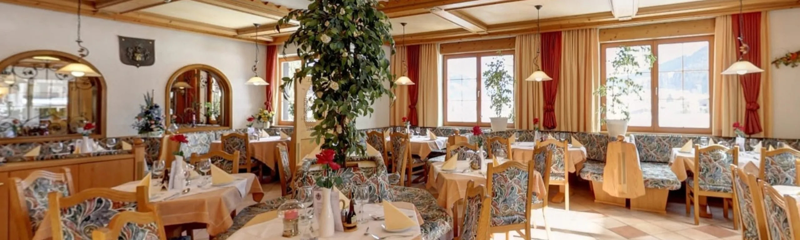 Elegantes Restaurant mit gemütlicher Einrichtung und Pflanzen.