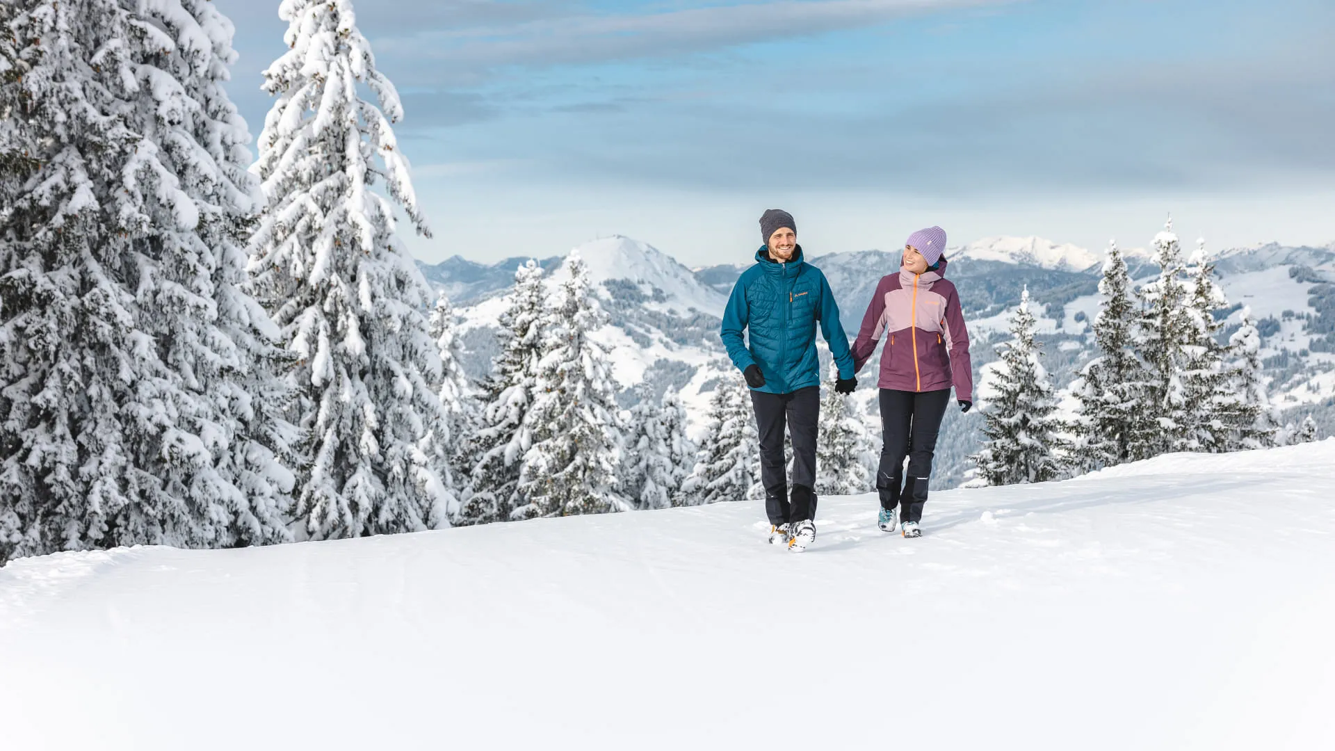 Winterwanderer im Brixental mit schneebedeckten Bäumen