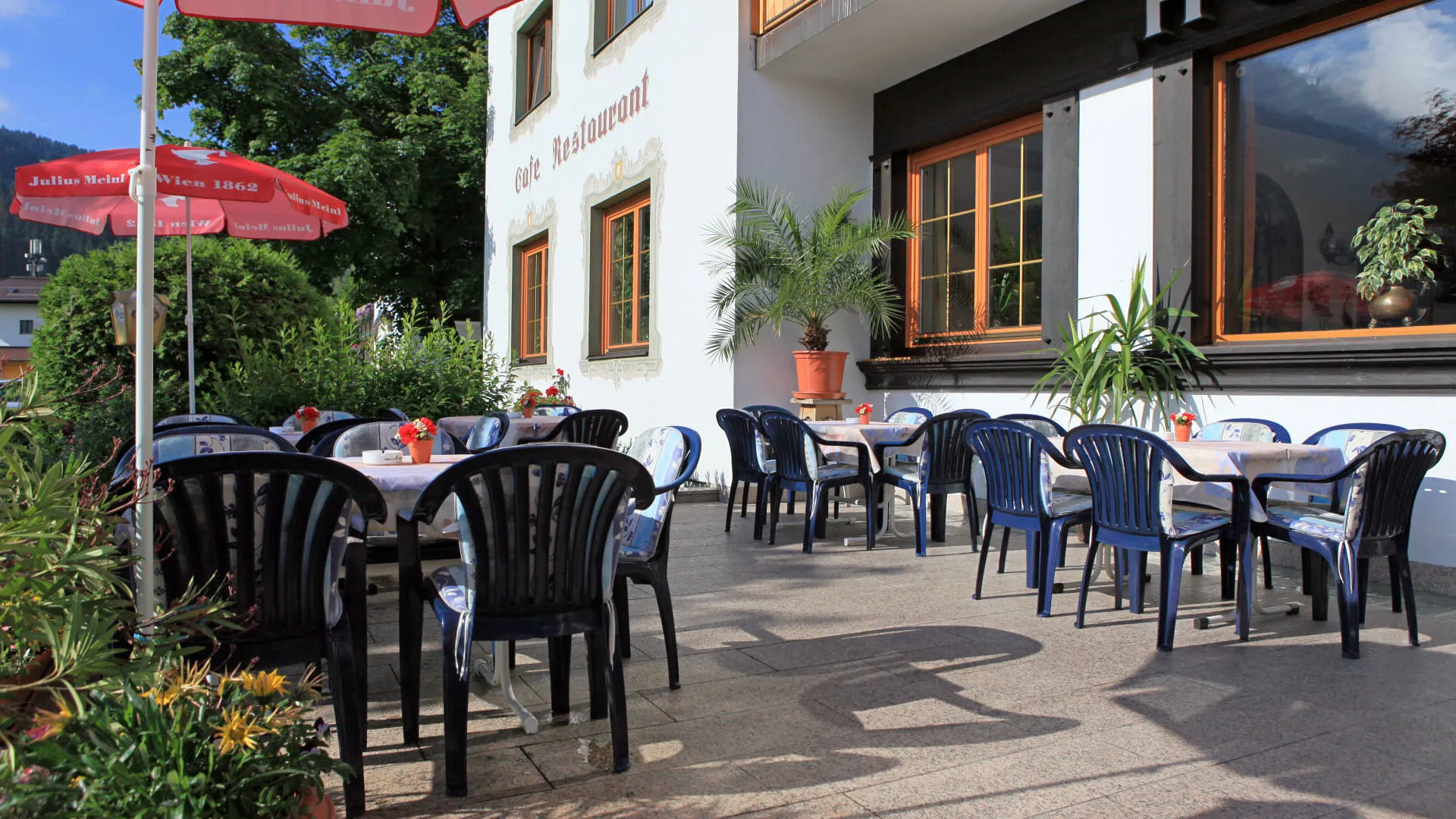 Terrasse mit Tischen und Stühlen am Hotel Briem