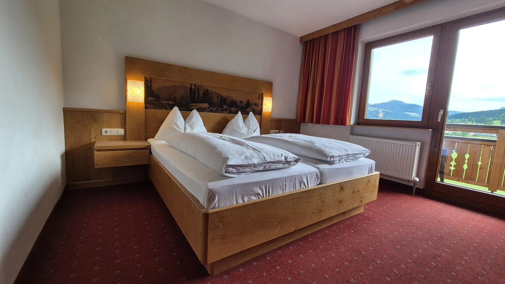 Gemütliches Hotelzimmer mit Doppelbett und Bergblick