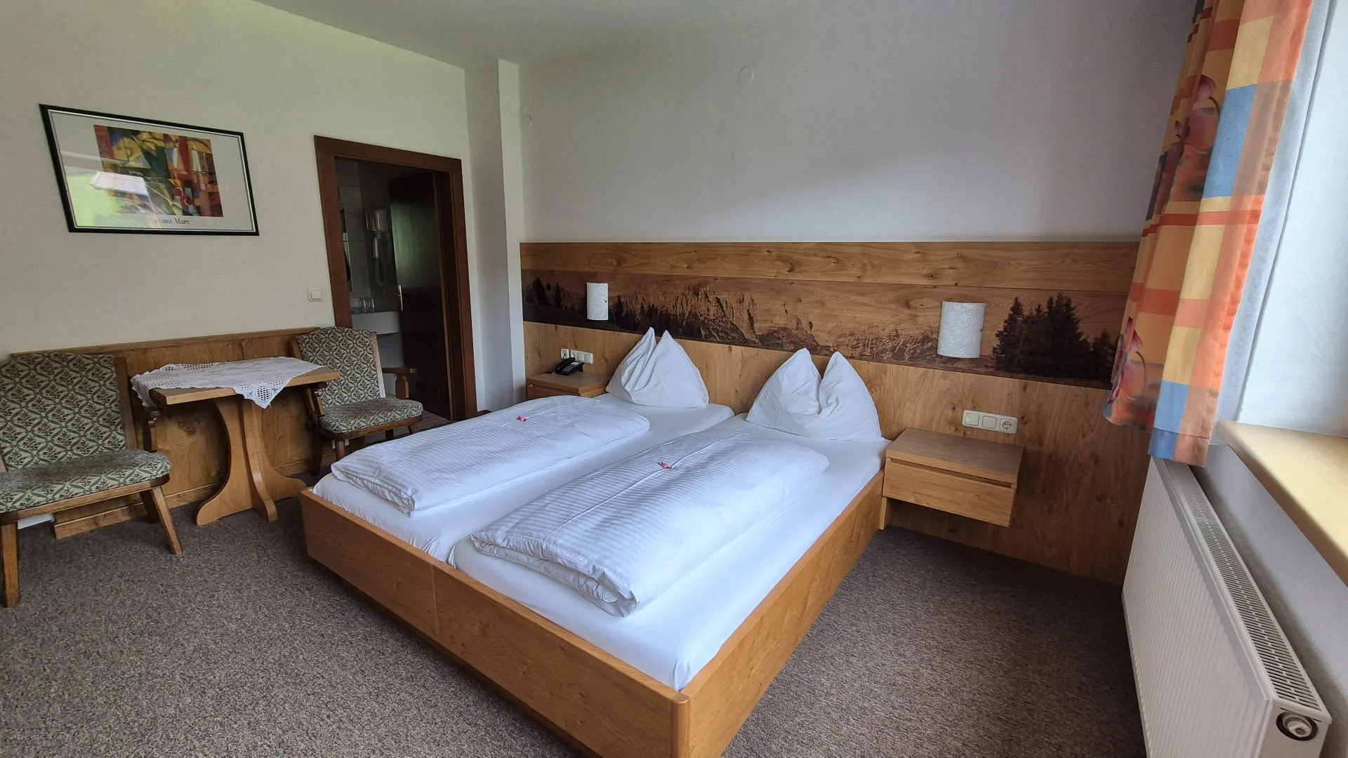 Zimmer mit zwei Betten und Möbeln aus Holz