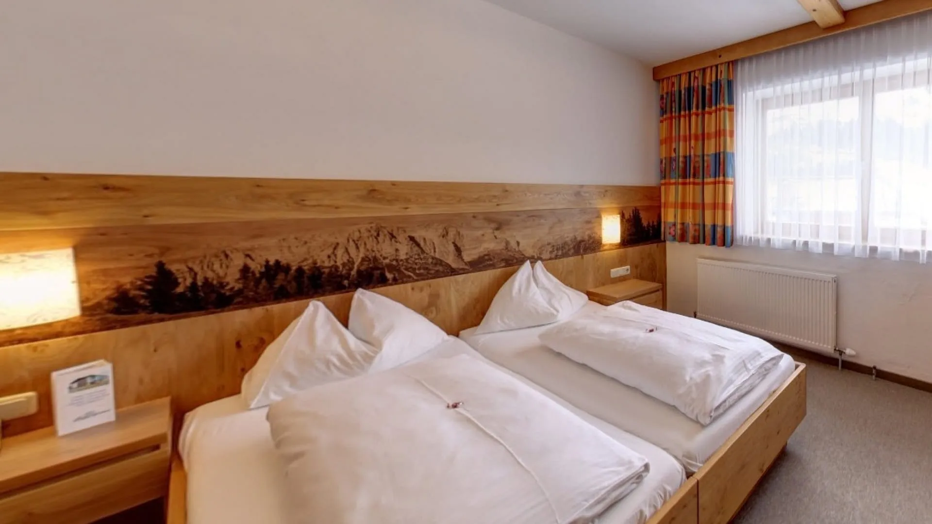 Gemütliches Schlafzimmer mit zwei Betten und Fenster.