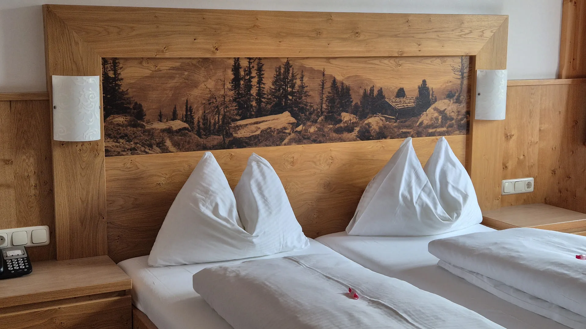 Doppelbett mit Holzkopfteil und zwei Kissen