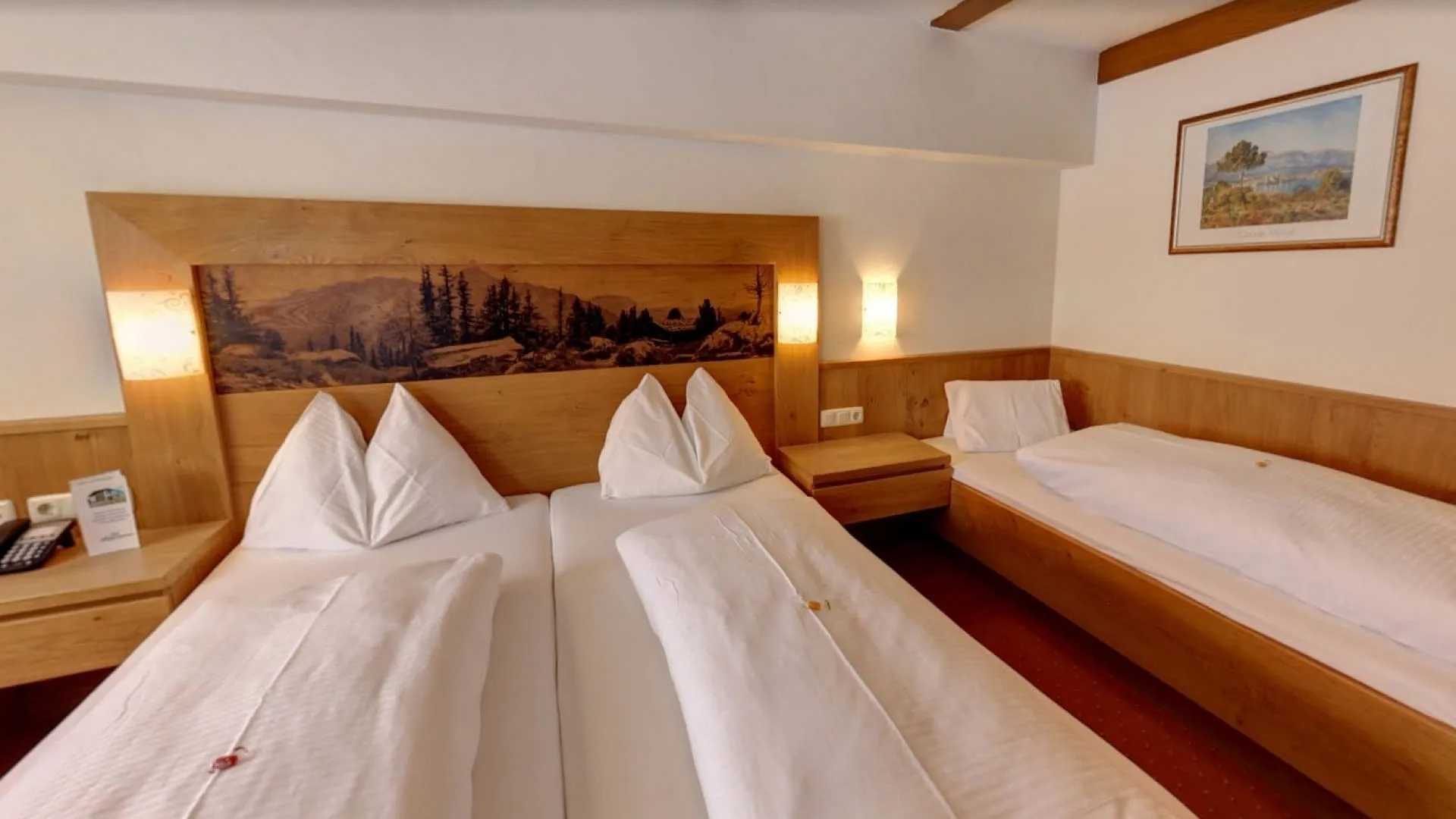 Dreibettzimmer mit Holzverkleidung und drei Betten